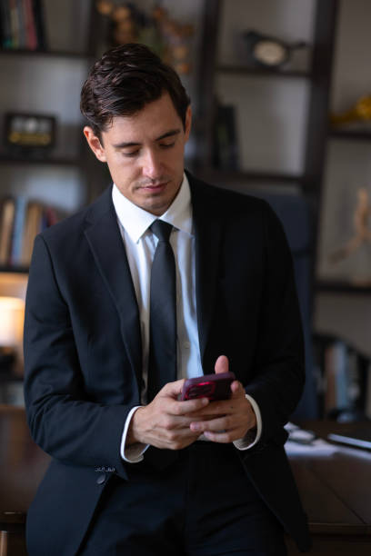 istock Young man in suit surfing on phone 2178956597