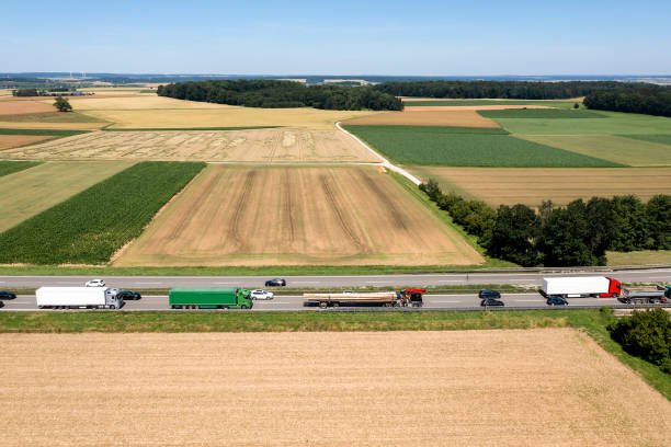 Aerial view of a summer landscape with a highway full of cars and trucks driving in heavy traffic.