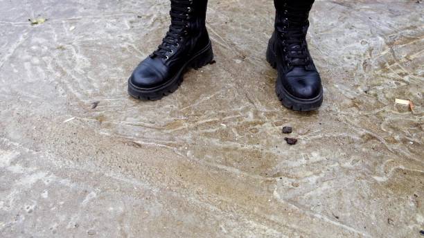 istock A soldier in army boots standing on a concrete area close up, copy space 2178967602