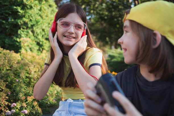 Smiling boy and girl with vintage cassette tape player. Retro style. Old school walkman. Listening music. Carefree enjoyment and personal satisfaction.