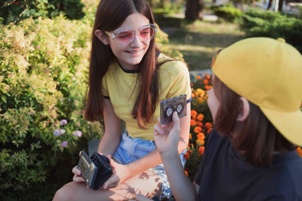Smiling boy and girl with vintage cassette tape player. Retro style. Old school walkman. Listening music. Carefree enjoyment and personal satisfaction.