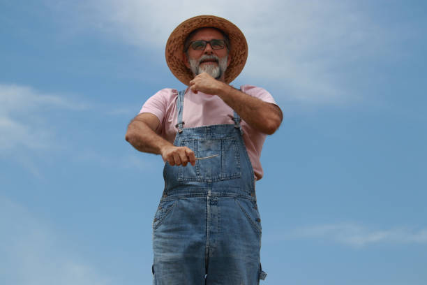 farmer hat portrait modern senior glasses beard sky background