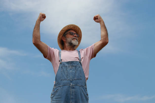 farmer hat portrait modern senior glasses beard sky background