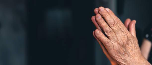 istock Elderly woman praying with hands. Hands folded in prayer. 2179005656