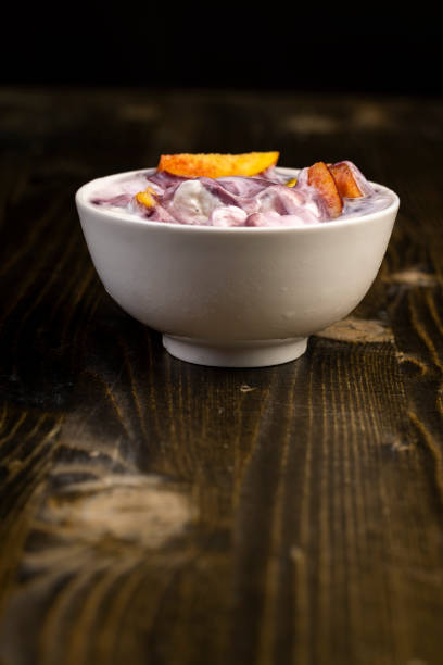 yogurt with jam and pieces of ripe nectarine, natural yogurt in a white bowl