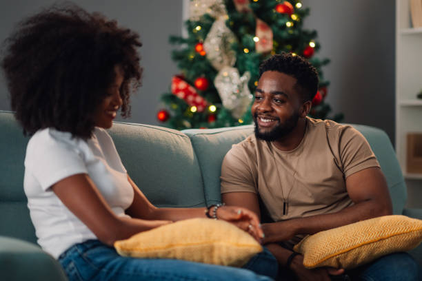 istock African american couple's engaging discussion on teal couch beside Christmas 2179008691