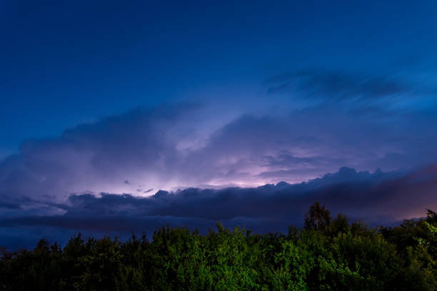 Thunderstorm, electrostatic discharge in the night sky, branching lightning high above the clouds. View of the dark sky.