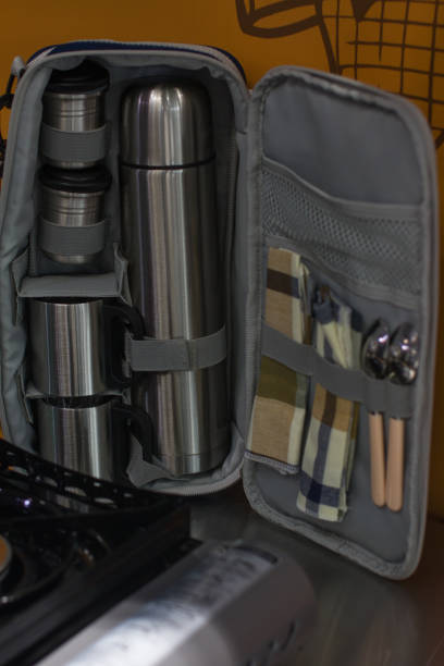 A camping travel kit with dishes. Cups, thermos, spoons and forks