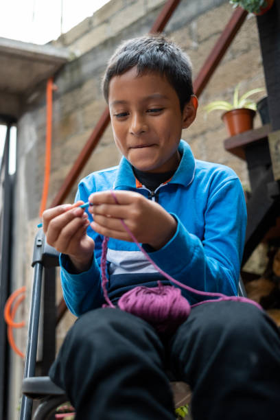 Mexican boy crocheting with a needle