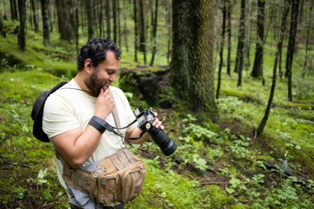 istock Mexican man looking at photographs in the forest 2179027371