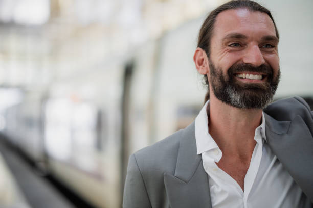 istock Happy businessman smiling looking away at train station 2179029692