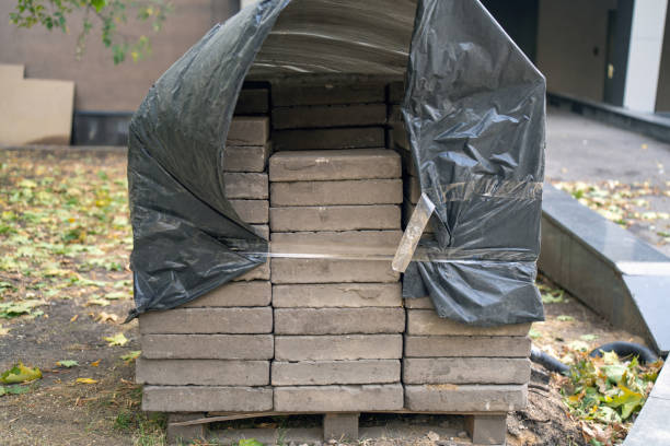 stacked pavement tiles draped in a billowing black plastic sheet, dancing in the wind. The contrast between structured geometry and fluid motion creates a captivating visual interplay