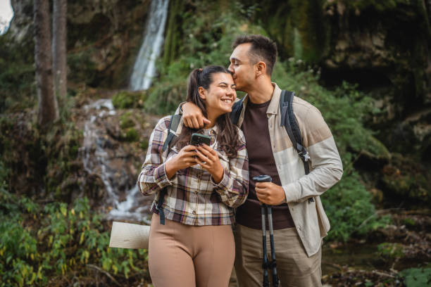 istock boyfriend kiss and hug girlfriend in front waterfall 2179045505