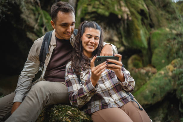 istock hugged hiker couple backpackers in front waterfall and use cellphone 2179047444