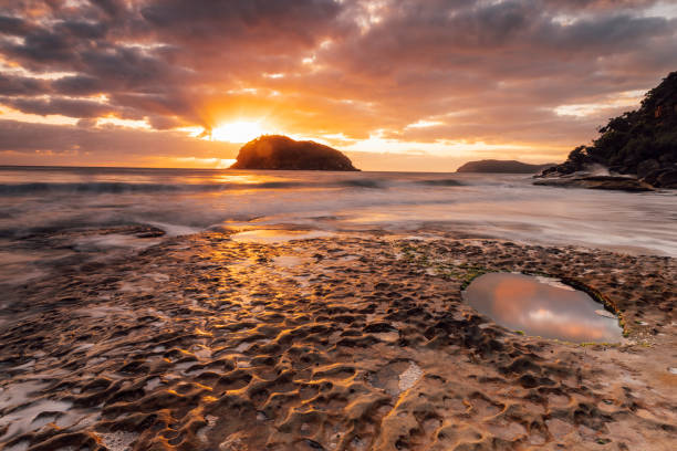 istock Distant Islands in the sun and foreground rock pools 2179069826