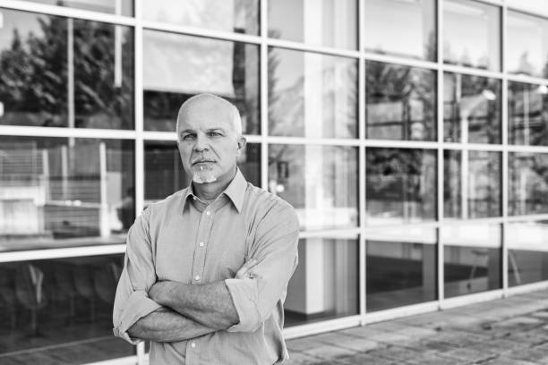 istock Serious senior engineer standing with arms crossed in front of m 2179072228