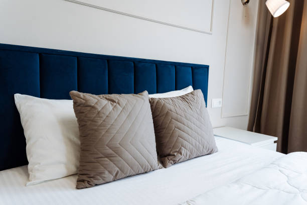 istock The room is elegantly decorated with a blue headboard bed and soft pillows, offering a comfortable and luxurious atmosphere. It exudes comfort and luxury, creating a welcoming space 2179079209