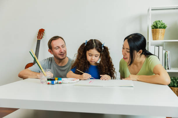 istock Family art session indoors with a child creating a drawing while parents support and engage in learning at home 2179087488