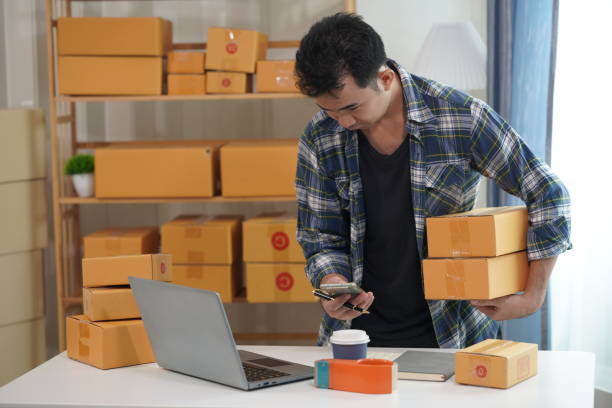 istock Entrepreneur of young Asian man working with laptop computer and boxes for ordering packaging from online shopping at home for SME business online 2179101984