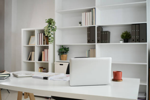 istock Laptop on white table with coffee cup, calculator and financial reports 2179105314