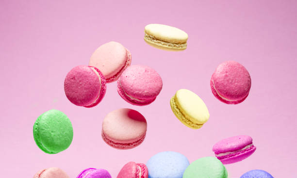 istock Colorful french macarons falling down isolated on pink background. 2179110461