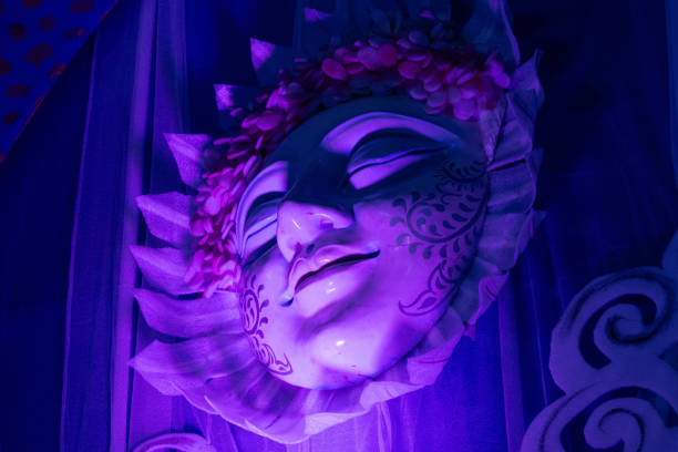 Beautiful face mask with pink geranium flower in full bloom and burgundy theater curtain.