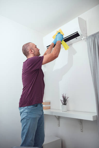istock Man cleaning and maintaining air condition unit at home. 2179114122