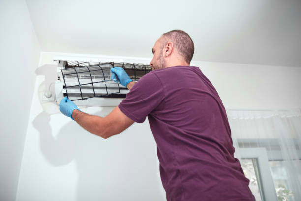 istock Man cleaning and maintaining air condition unit at home. 2179114201