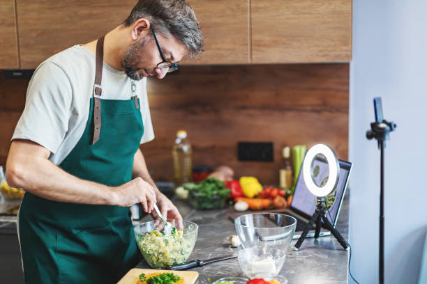 istock Mid adult man cooking and streaming 2179114324