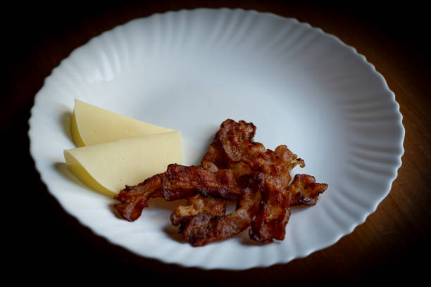 istock fried bacon and two slices of cheese on white plate 2179115099