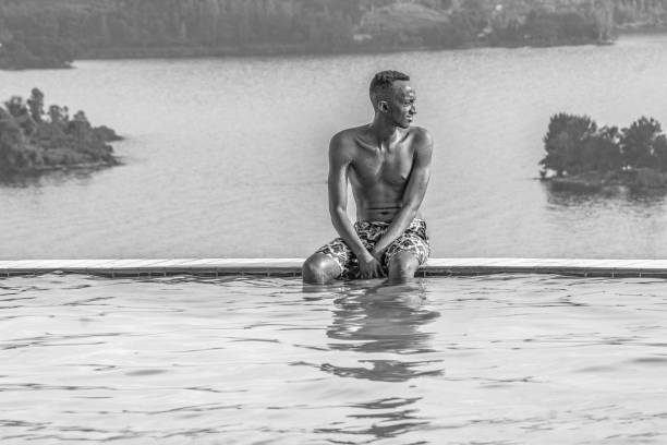 Midsection Of Mature Woman In Bikini Swimming In Swimming Pool Against Sky