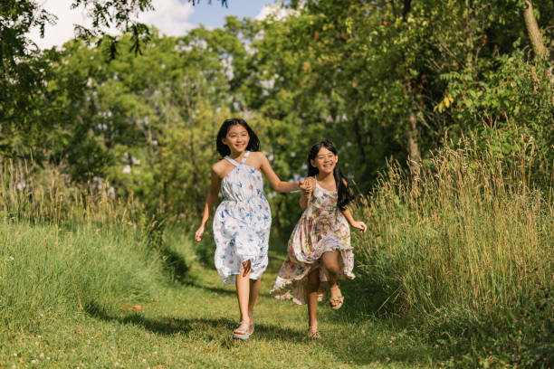 istock Carefree Asian sisters having fun while running in nature. 2179125510