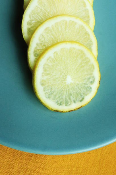 Pile of fresh lemon slices on blue plate