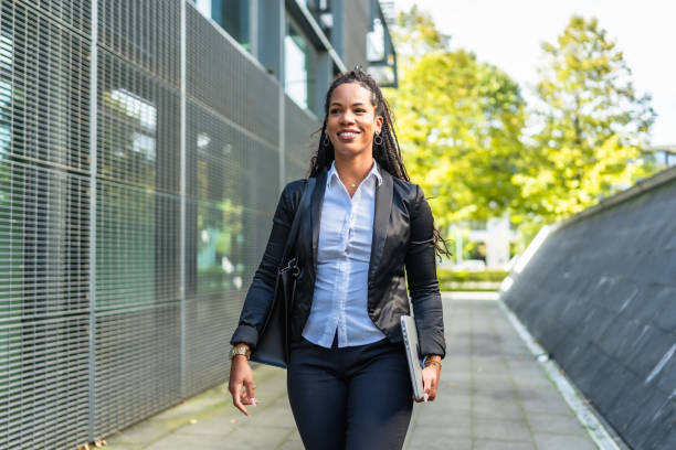 istock Real estate agent walking outside building holding laptop 2179140212