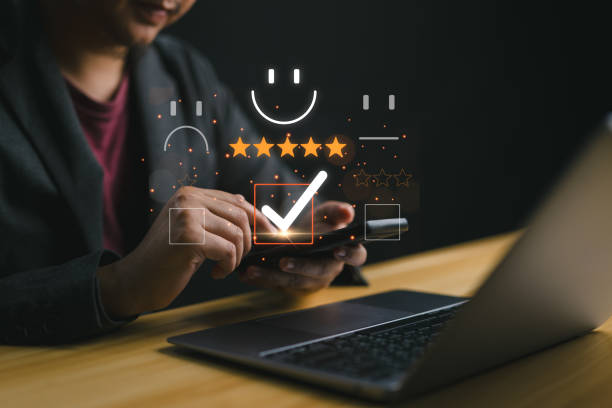 istock Customer service evaluation concept. Smiling man is using a smartphone, and she is pressing a face emoticon smile in satisfaction on the virtual touch screen. 2179148251