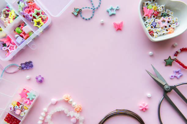 istock Crafting colorful beaded jewelry with charms and scissors on a pink surface in a creative workspace 2179148761