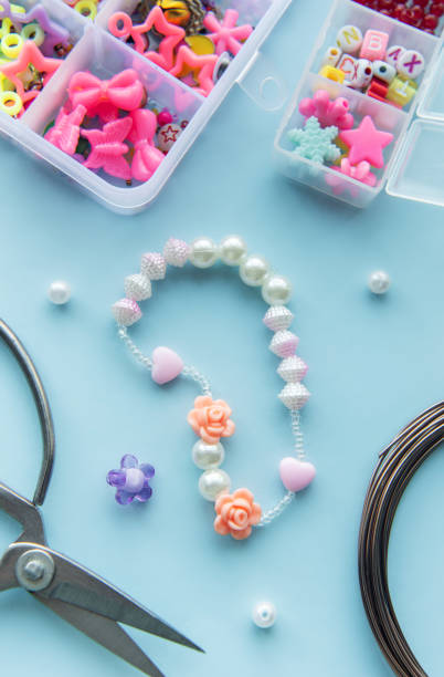 istock Crafting a charming beaded bracelet with colorful resin charms and tools on a light blue workspace 2179148770