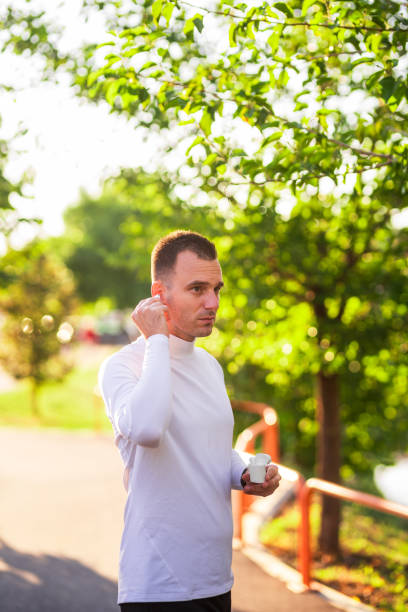 istock Sportsman putting earbuds getting ready for training outdoors 2179150656