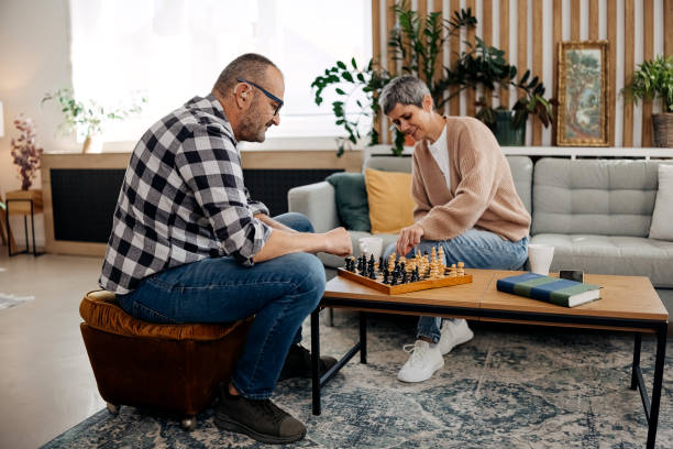 istock Couple playing chess at home 2179150802