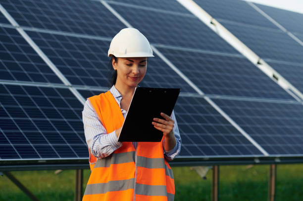 istock Notepad in hands. Female worker engineer in uniform is near solar panels 2179152865