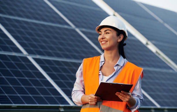 istock Notepad in hands. Female worker engineer in uniform is near solar panels 2179152868