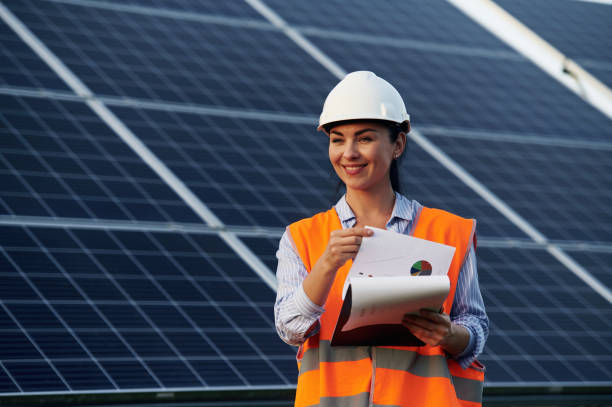 istock Notepad in hands. Female worker engineer in uniform is near solar panels 2179152891