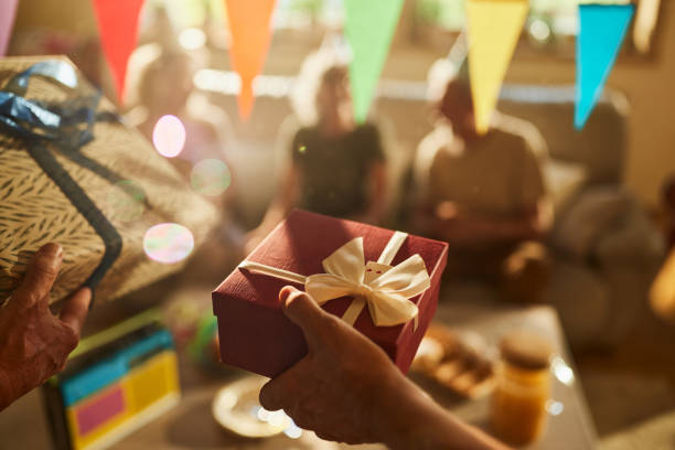 Close up of unrecognizable people bringing gifts on a Birthday party.