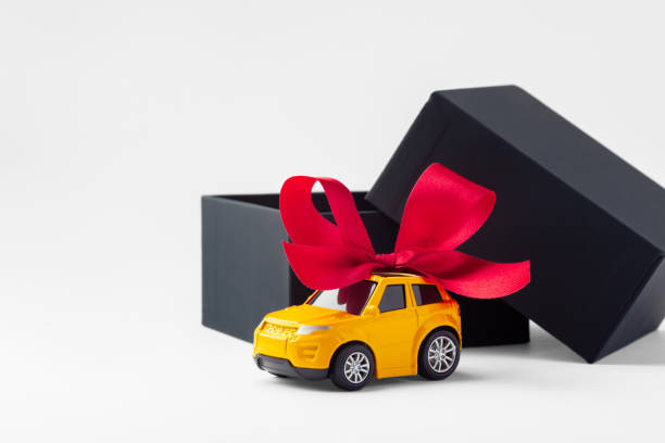 istock Car toy with red bow and black gift box opened on white background 2179155934