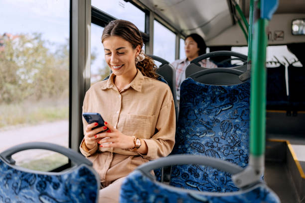 istock Smiling beautiful woman text messaging while riding in public bus 2179157218