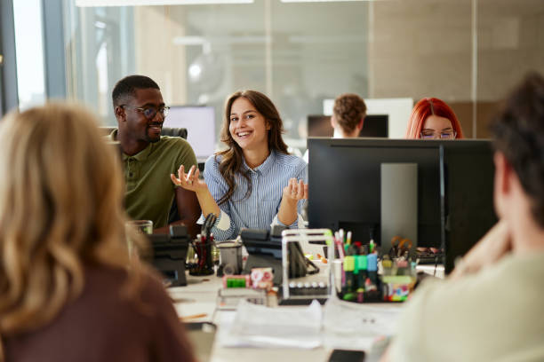 istock Happy female programmer talking to her colleagues in the office. 2179157224