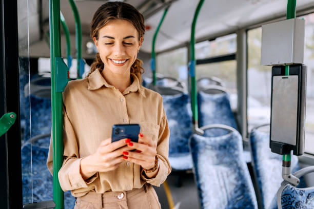 istock Smiling beautiful woman text messaging while riding in public bus 2179157263