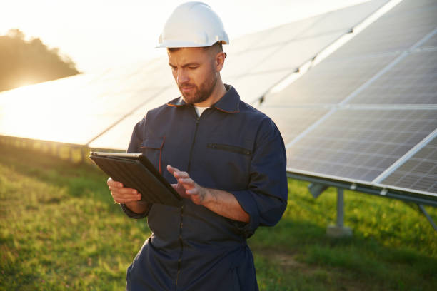 istock Reflection of the sunlight behind. Man is working with solar panels outdoors at daytime 2179159888