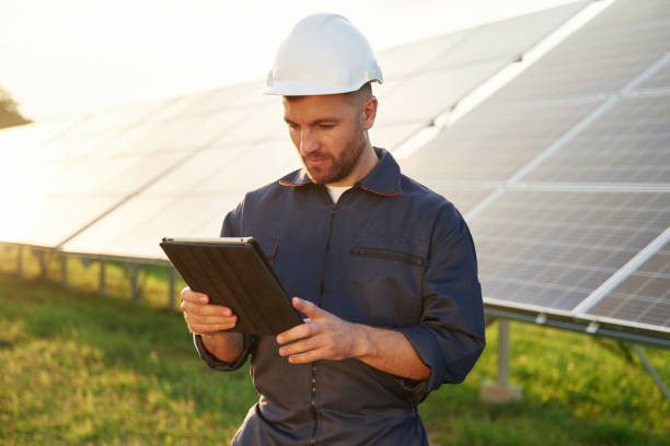 istock Reflection of the sunlight behind. Man is working with solar panels outdoors at daytime 2179159890