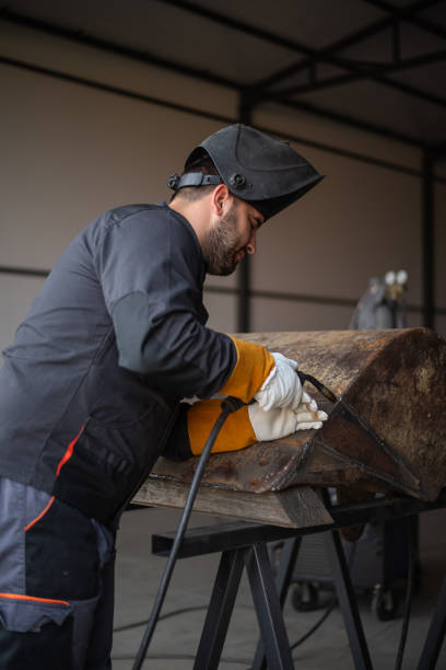 istock Professional welder joining metal parts using welding torch in workshop 2179159921